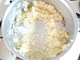 オリーブオイルで玉ねぎをしんなりするまで炒める。米を加え、さらに炒める。
