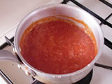 トマトソースを作る。鍋にオリーブオイルを入れ、玉ねぎのみじん切りを炒める。余分な水分がなくなったら、トマトピューレを加えて煮詰め、塩で味を整える。