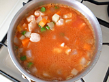 鶏ささみを加え、軽く炒る。トマト水煮缶と水を加えて強火にする。